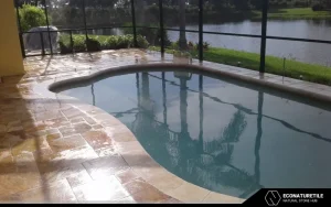 picture of a pool where the travertine deck around it has gotten wet