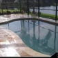 picture of a pool where the travertine deck around it has gotten wet